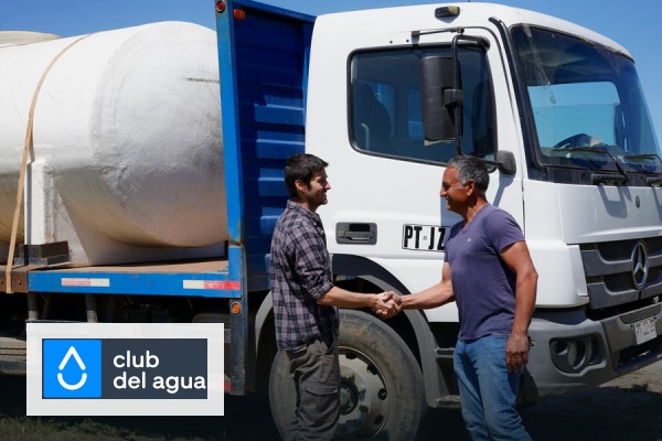 Equipo de Club del Agua junto a un camión de reparto de estanques de agua en Chile