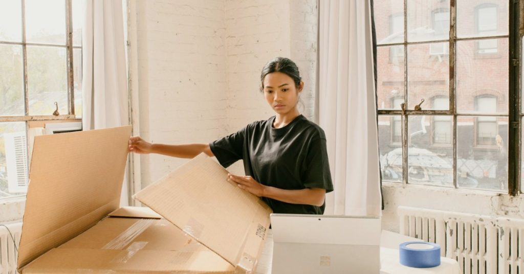 Emprendedora preparando un pedido con papel kraft, embalaje sustentable para tiendas online