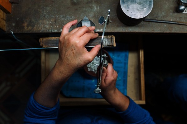 Manos de artesana trabajando una pieza de Cordillerana