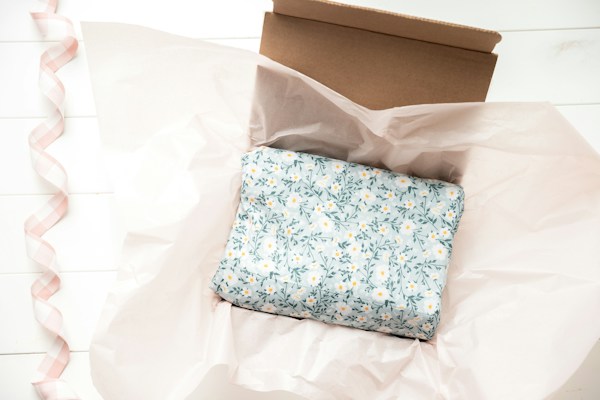 Caja abierta con papel de seda y un regalo envuelto, una experiencia de unboxing sin plástico