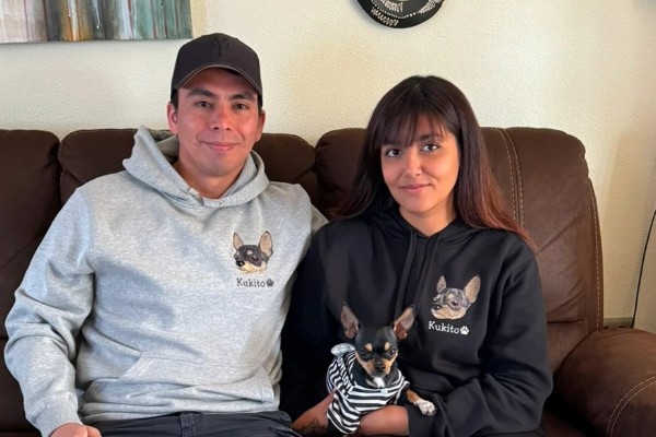 Pareja con polerones bordados de Malcriados junto a su chihuahua