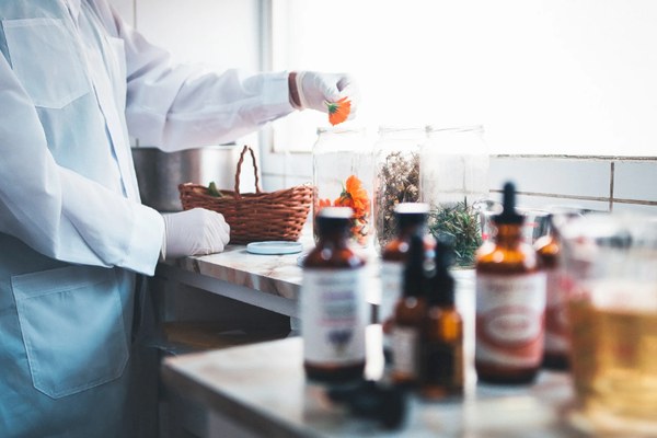 Laboratorio de cosmética natural con frascos de vidrio y plantas